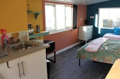 a kitchen with a sink and a bed in a room at Redwood Lodge, Dee Valley Stays - cosy microlodge with detached private shower & WC in Corwen