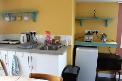 a kitchen with a sink and a counter top at Redwood Lodge, Dee Valley Stays - cosy microlodge with detached private shower & WC in Corwen