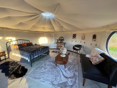 a bedroom in a tent with a bed and a table at Heart of the Wye in Clifford