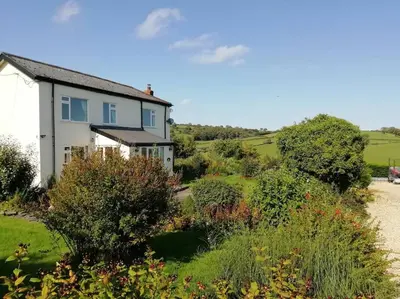 a house on the side of a hill with bushes at Country Home with Gardens in Newtown