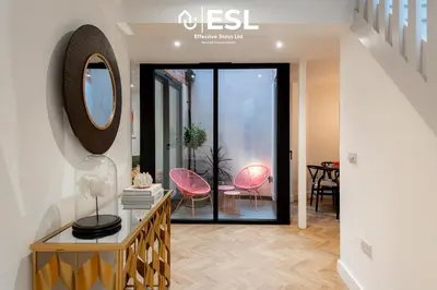 a living room with a mirror and pink chairs at Contemporary Townhouse - Free Parking - Central Shrewsbury in Shrewsbury