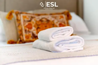 a stack of towels sitting on top of a bed at Contemporary Townhouse - Free Parking - Central Shrewsbury in Shrewsbury