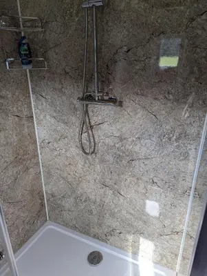 a shower in a bathroom with a stone wall at Red darren luxury hut in Llanveynoe