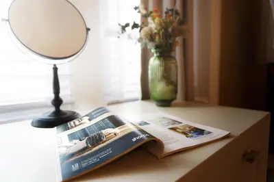 a book on a table with a lamp and a mirror at Loft Fach in Tregaron