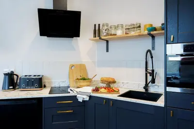 a kitchen with blue cabinets and a sink at Loft Fach in Tregaron