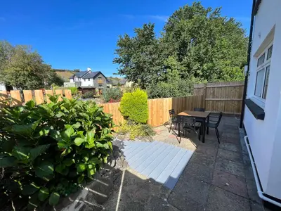 a backyard with a table and chairs and a fence at Escapism Wales Gwalia in Llanrhystyd