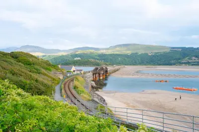 a view of a beach with a train on the tracks at 2 Bed in Barmouth oc-wag721 in Barmouth