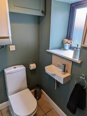 a bathroom with a white toilet and a sink at The Cob House. in Ifton Heath