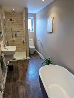 a bathroom with a tub and a sink and a toilet at The Cob House. in Ifton Heath