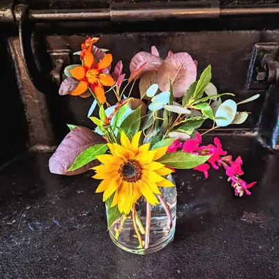 a vase filled with flowers on a table at The Cob House. in Ifton Heath