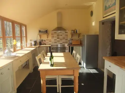 a kitchen with a table with a bottle of wine on it at Baddegai Holiday Cottage in Brecon