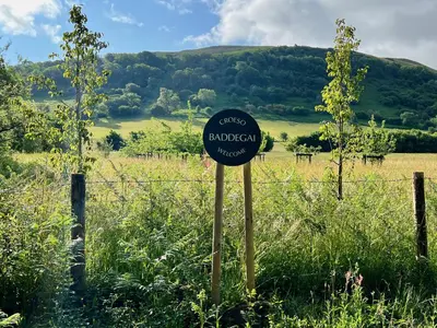 a sign in a field next to a fence at Baddegai Holiday Cottage in Brecon