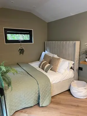 a bedroom with a large bed with a window at Berwyn Lodge with private hot tub in Llangollen