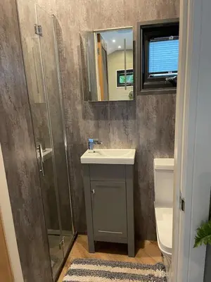 a bathroom with a sink and a shower at Berwyn Lodge with private hot tub in Llangollen