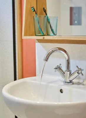 a bathroom sink with water running from a faucet at Kin Ludlow Rooms in Ludlow