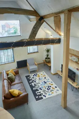 a living room with a leather couch and a rug at Kin Ludlow Rooms in Ludlow
