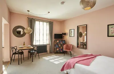 a bedroom with a bed and a table and chairs at Kin Ludlow Rooms in Ludlow