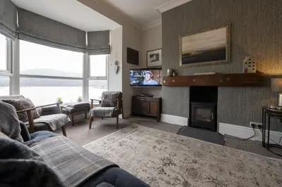 a living room with a couch and a fireplace at Harbour View - Flat 2 - Tudor House in Barmouth