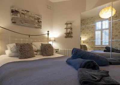 a bedroom with a large bed and a large mirror at Harbour View - Flat 2 - Tudor House in Barmouth