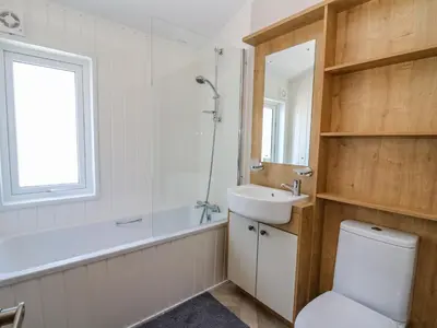 a bathroom with a toilet and a sink and a shower at Ystwyth 36 in Borth