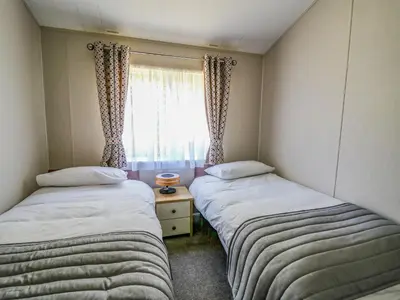 two beds in a small room with a window at Ystwyth 36 in Borth
