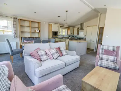 a living room with a couch and a kitchen at Ystwyth 36 in Borth