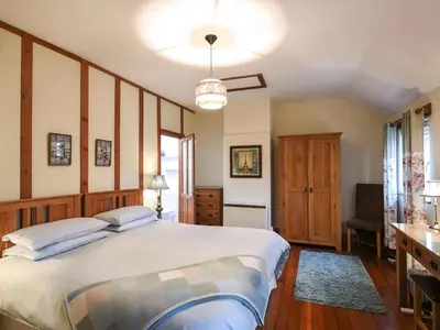 a bedroom with a large bed and a desk at Heron Cottage in Bishops Castle