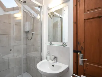a bathroom with a sink and a shower at Heron Cottage in Bishops Castle