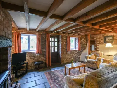 a living room with two couches and a tv at Heron Cottage in Bishops Castle