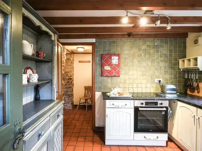 a kitchen with a stove top oven in a room at Curlew Cottage in Bromlow