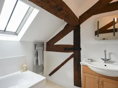 a bathroom with a white sink and a bath tub at Grove Farm Cottage in Condover