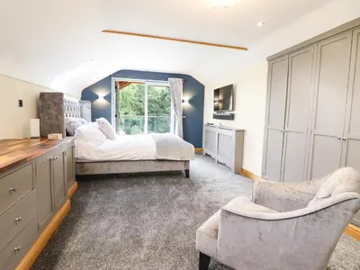 a bedroom with two beds and a window at Tyn Y Ceubren Bach at Evelyns Retreat in Corwen