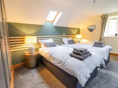 a bedroom with two beds with towels on them at Tyn Y Ceubren Bach at Evelyns Retreat in Corwen