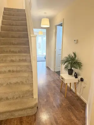 a staircase in a home with a table and a plant at Family home close to Shrewsbury Town centre in Shrewsbury
