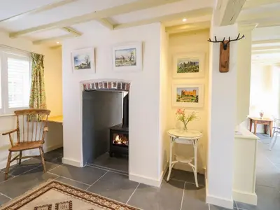 a living room with a fireplace and a chair at Tan Y Ddol in Welshpool
