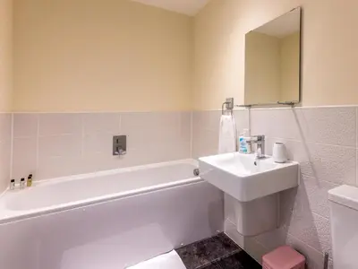 a bathroom with a white tub and a sink at Stylish modern two bedroom home in Shrewsbury - Pass the Keys in Shrewsbury