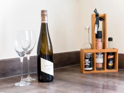 a bottle of wine and two glasses on a counter at Stylish modern two bedroom home in Shrewsbury - Pass the Keys in Shrewsbury