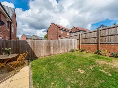 a backyard with a wooden fence and a table at Stylish modern two bedroom home in Shrewsbury - Pass the Keys in Shrewsbury