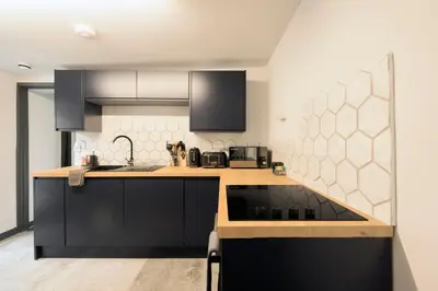 a kitchen with black cabinets and a counter top at Seafront apartment with balcony, parking and sea views in Aberystwyth