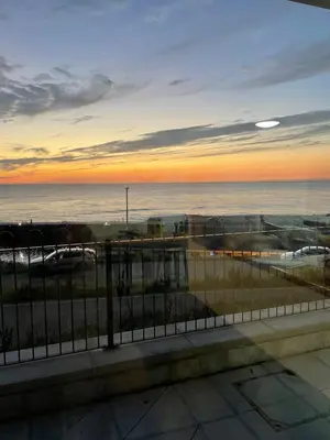 a view of the ocean at sunset from a balcony at The New 2 Plas Morolwg in Aberystwyth