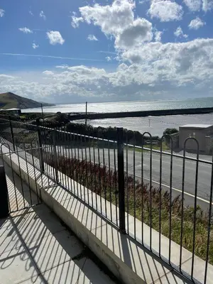 a view of the beach from a fence at The New 2 Plas Morolwg in Aberystwyth