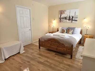a bedroom with a bed and a painting on the wall at Luxury 5 bedroom Riverside home in town centre - Pass the Keys in Shrewsbury