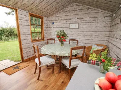 a dining room with a table and chairs in a cabin at Sweet Briar Shepherds Hut in Brecon
