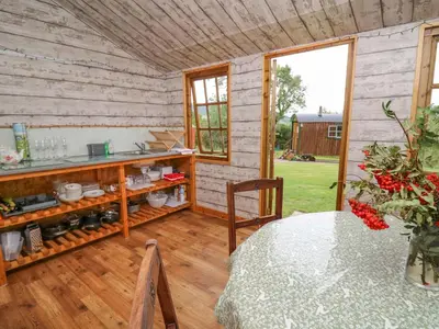 a room with a table and a counter with a window at Sweet Briar Shepherds Hut in Brecon