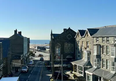 a view of a city street with buildings and the ocean at Luxury 4 Bedroom Seaside Apartment - Glan Y Werydd House in Barmouth