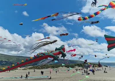 a group of people flying kites on a beach at Luxury 4 Bedroom Seaside Apartment - Glan Y Werydd House in Barmouth