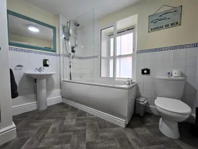 a bathroom with a tub and a toilet and a sink at Luxury 4 Bedroom Seaside Apartment - Glan Y Werydd House in Barmouth
