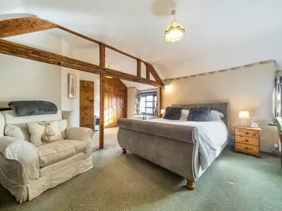 a large bedroom with a bed and a couch at 18th Century Farmhouse, England Wales Border, Breathtaking Views in Oswestry