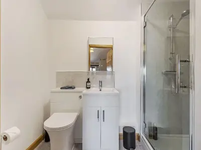 a white bathroom with a toilet and a shower at 18th Century Farmhouse, England Wales Border, Breathtaking Views in Oswestry