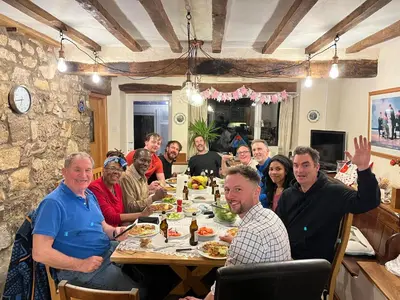 a group of people sitting around a table eating at 18th Century Farmhouse, England Wales Border, Breathtaking Views in Oswestry